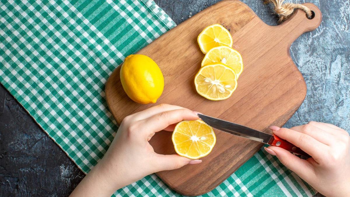 На разделочной доске нарезают лимон