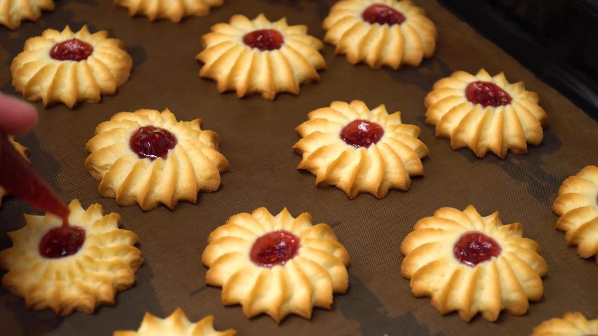 На противне испеченное печенье курабье, которое дополняют джемом