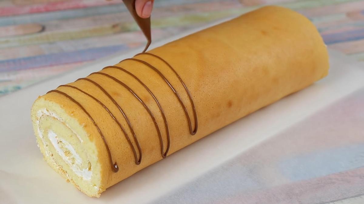 Рулет покрывают шоколадом из кондитерского мешка