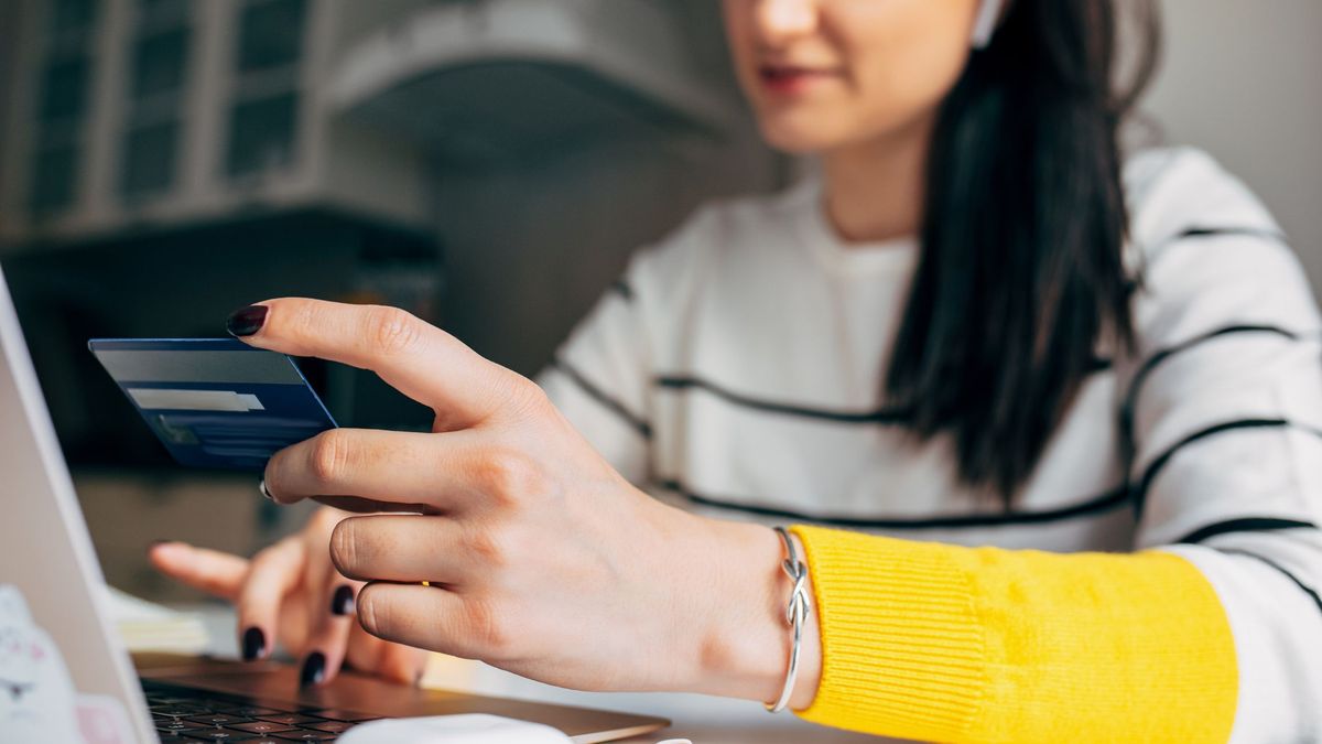 Женщина за ноутбуком с банковской картой