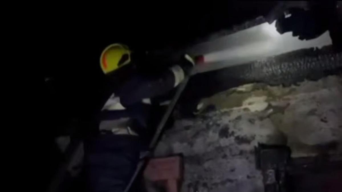 Пожарный тушит возгорание в жилом доме
