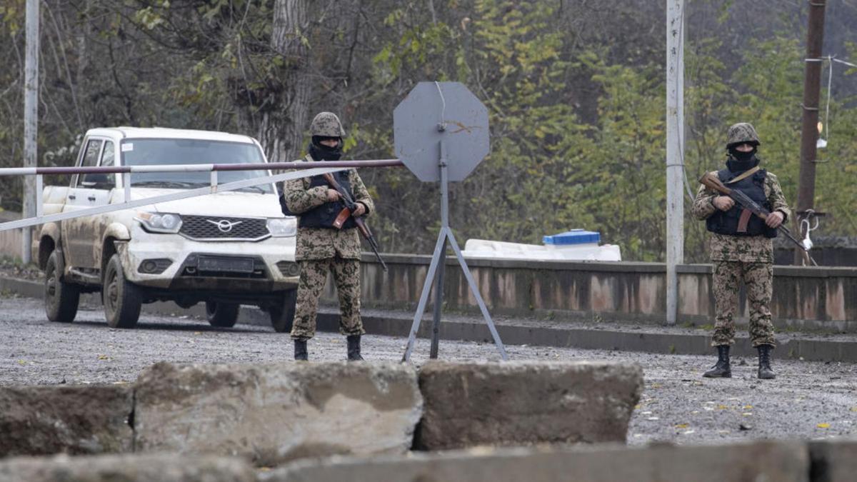 Военные стоят с оружием в руках