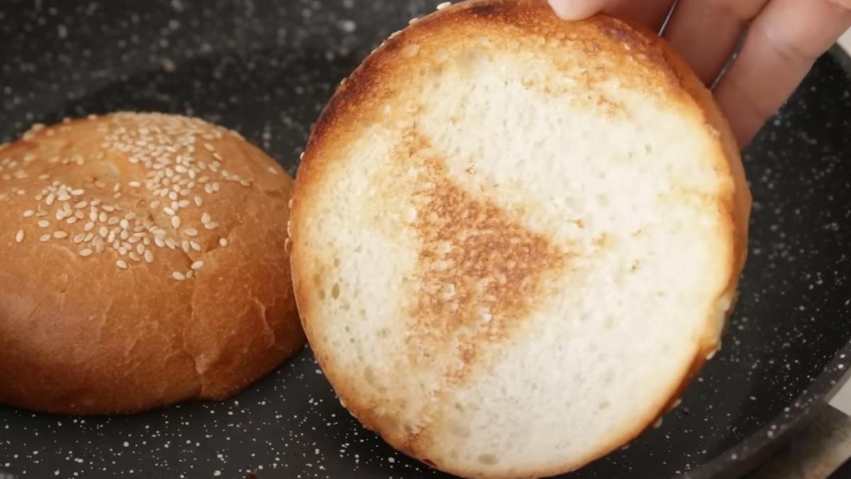 Разрезанная булочка жарится на сковороде до золотистой корочки