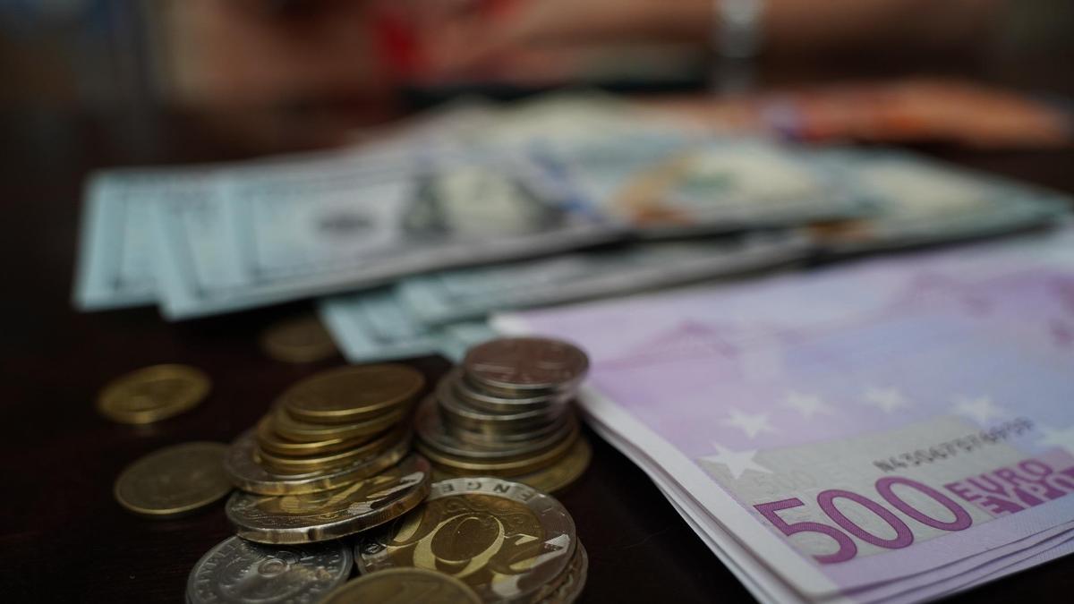 Купюры и монеты валют разных стран лежат на столе