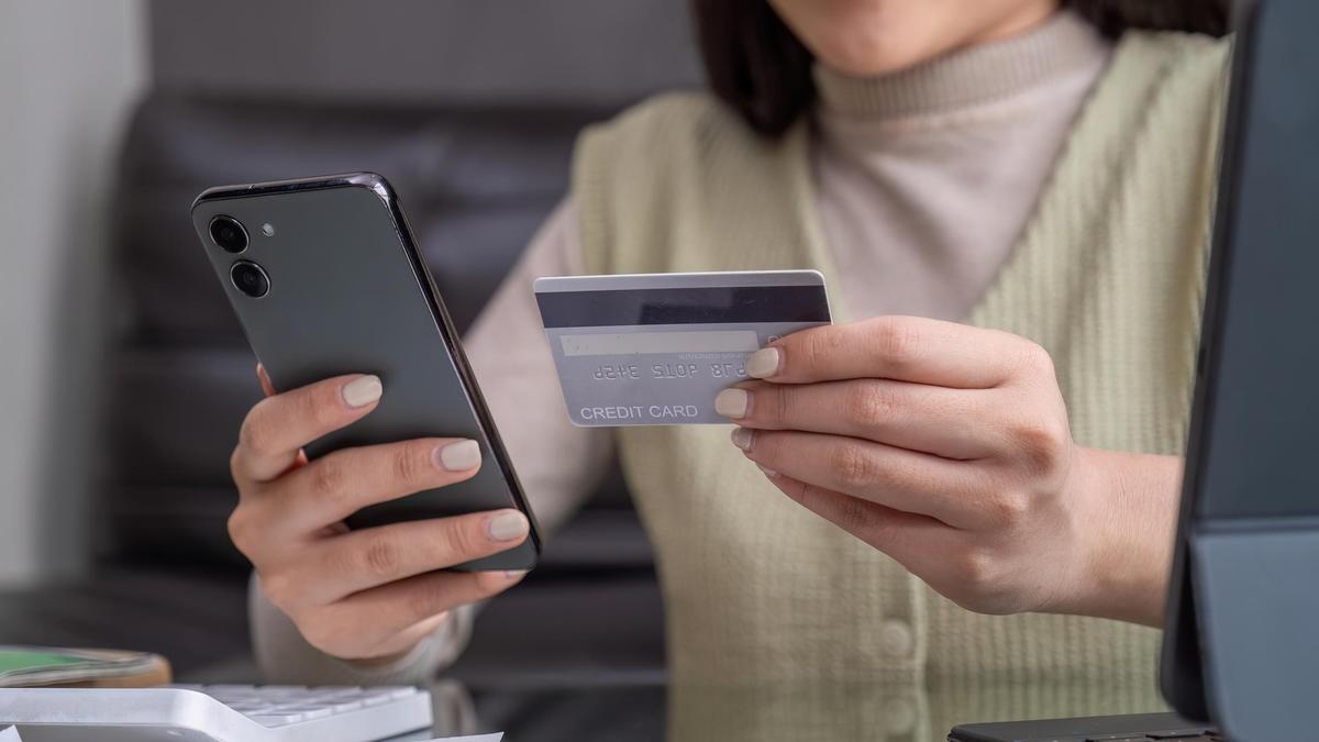 Женщина переводит деньги по телефону Женщина переводит деньги по телефону
