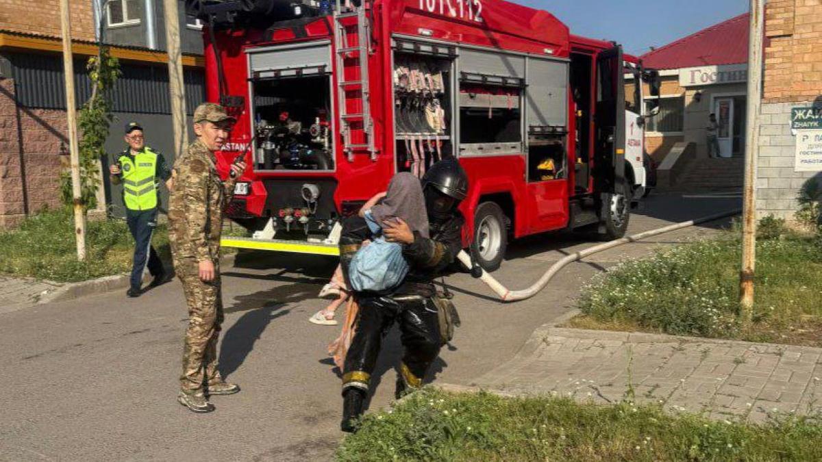 Пожарный несет на руках ребенка Пожарный несет на руках ребенка