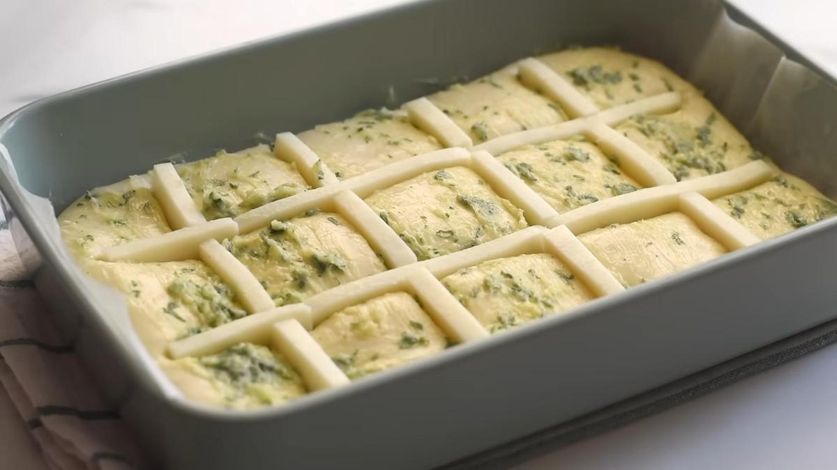 В форме для выпечки заготовка хлеба с сыром и чесноком