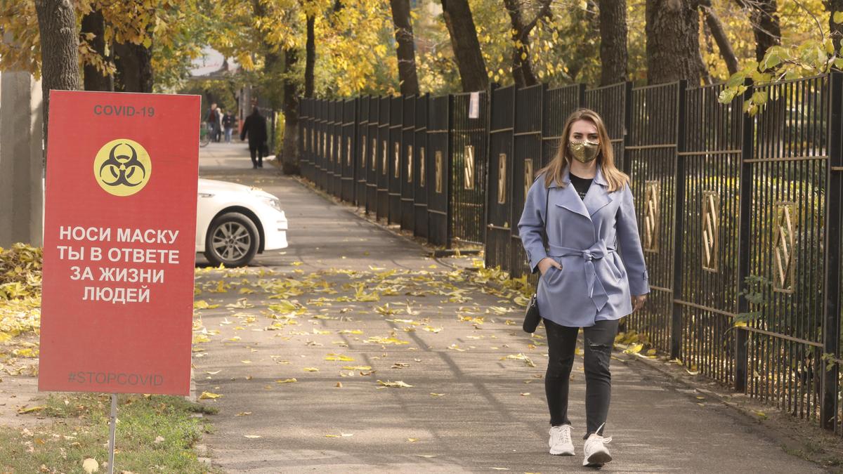 Девушка в маске идет по улице