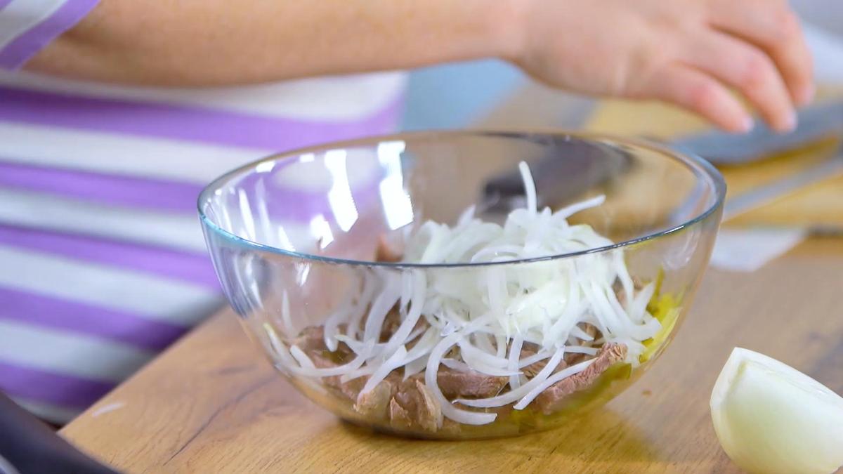 В салатнике нарезанные огурцы, мясо и лук