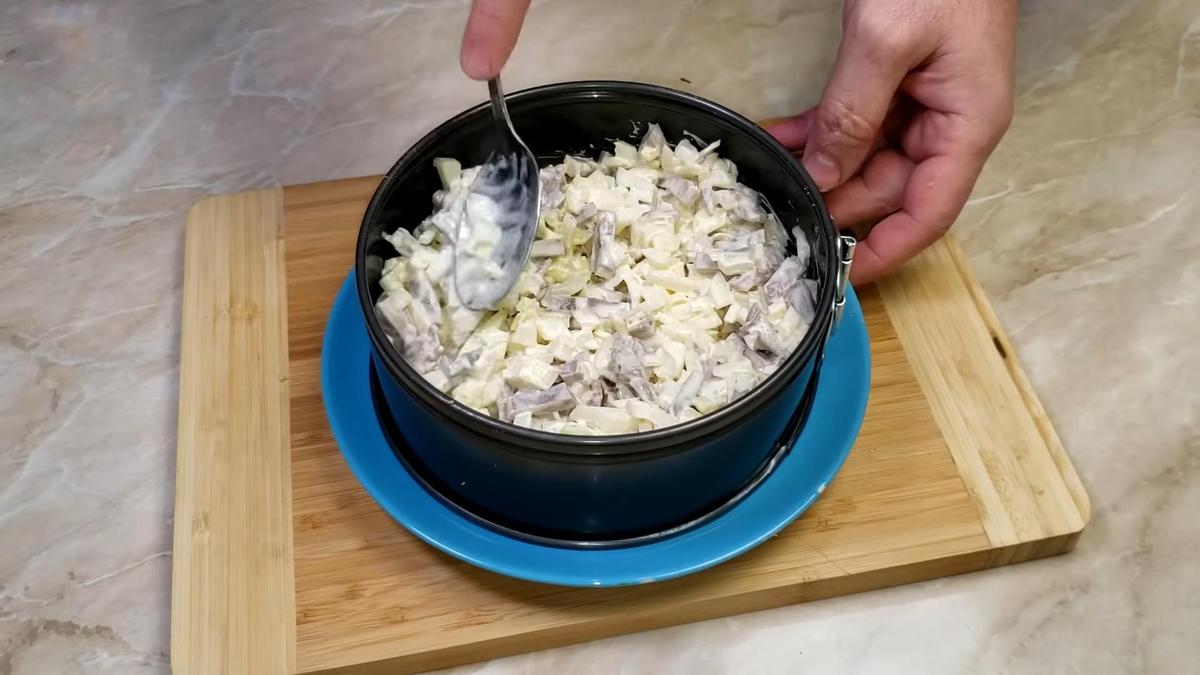 Слой мяса с луком разравнивают ложкой