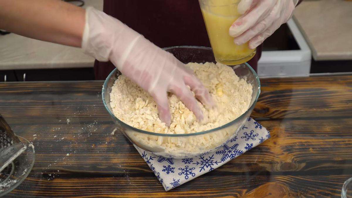 Добавление жидких ингредиентов в миску с масляно-мучной крошкой