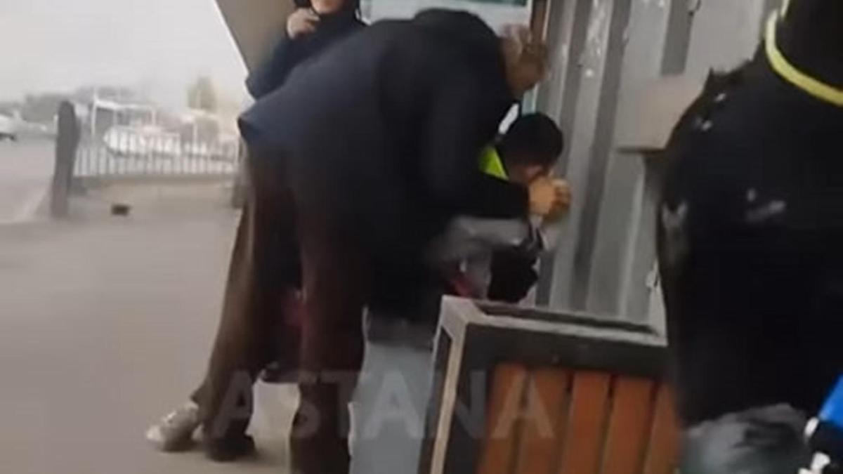 Баланың қолын қайырып жатқан ер адам Баланың қолын қайырып жатқан ер адам