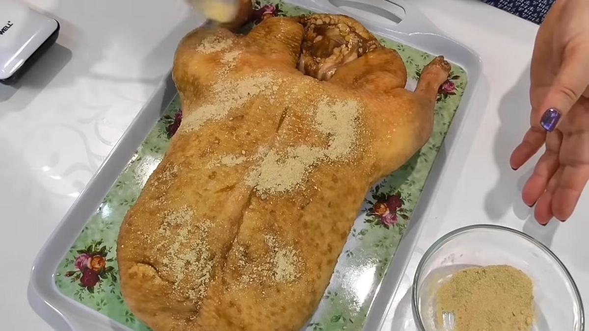 Тушка утки на подносе, посыпанная сушеным чесноком