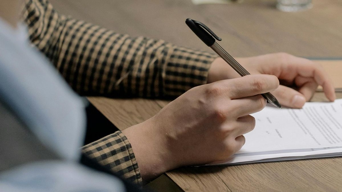 Мужчина подписывает документ