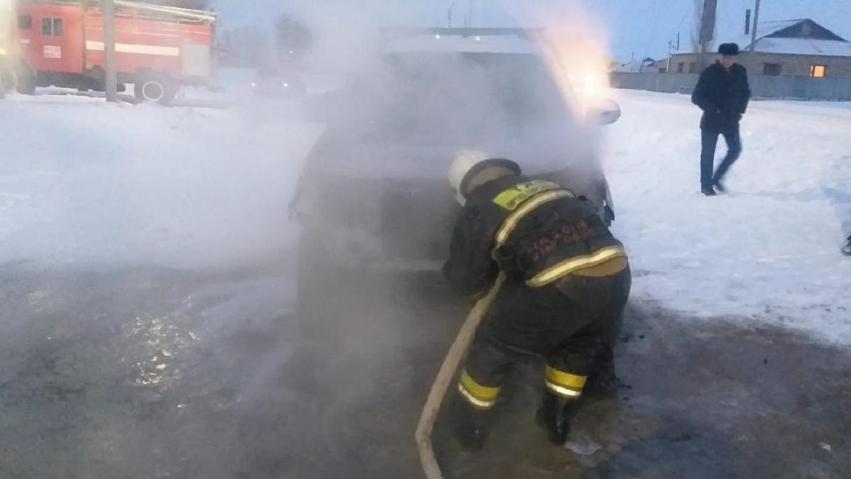 Пожарный тушит автомобиль