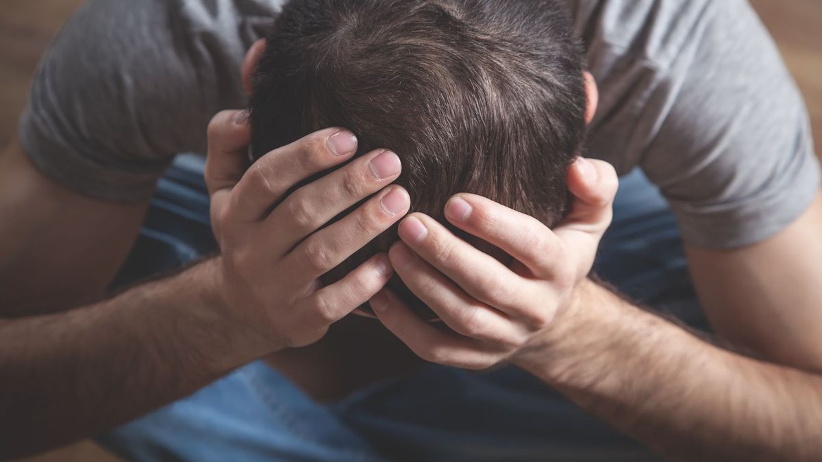 Мужчина держится руками за голову