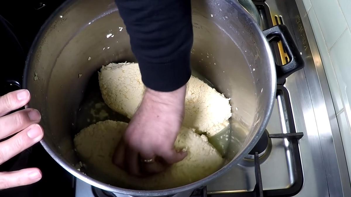 В кастрюле переворачивают куски сырной массы