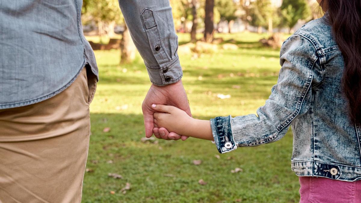 Мужчина держит дочь за руку