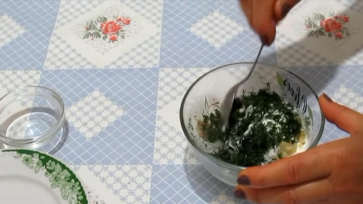 В сметану добавляют зелень и перемешивают ложкой