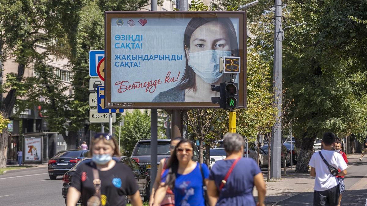 Люди в масках идут по улице Люди в масках идут по улице