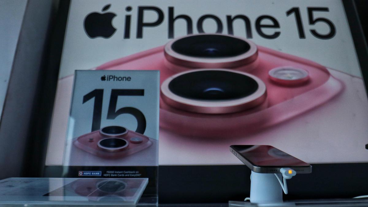 Прилавок магазина с рекламой iPhone 15 на фоне