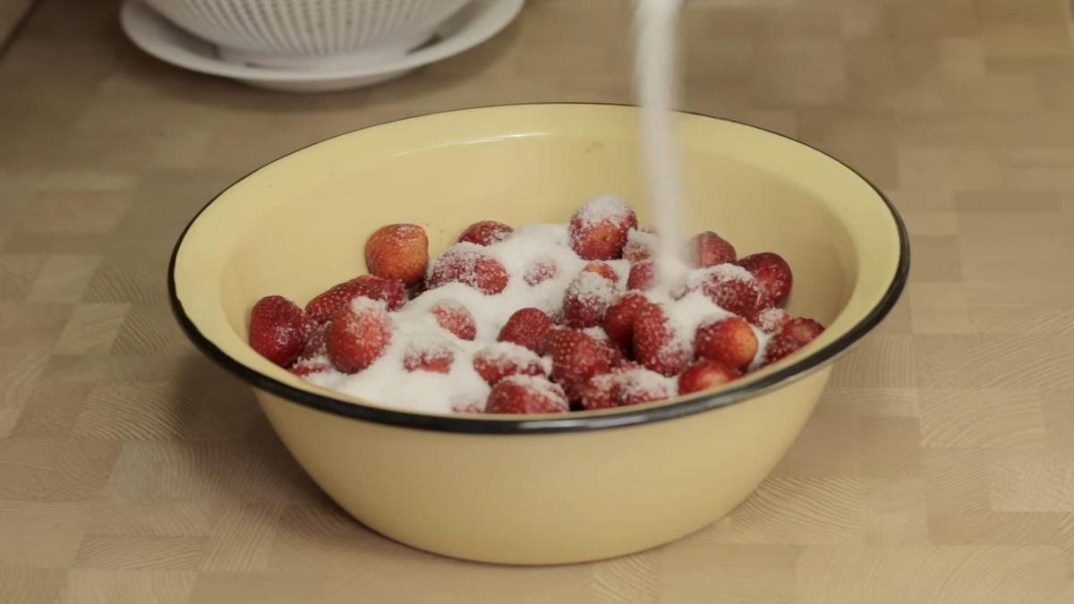 Сахар насыпают в эмалированную миску к клубнике