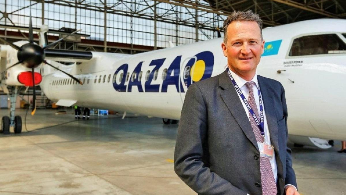 Мужчина стоит на фоне самолета Qazaq Air