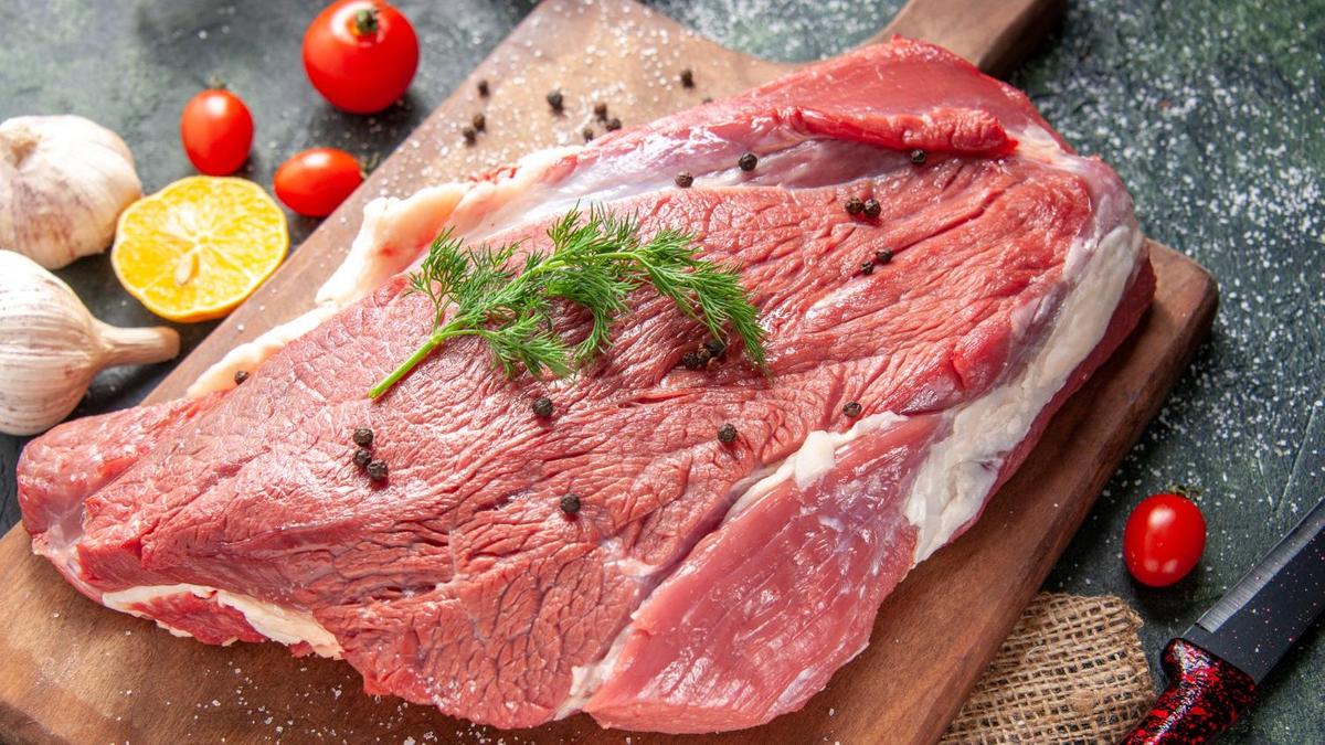 Свежая говяжья мякоть на доске с душистым перцем