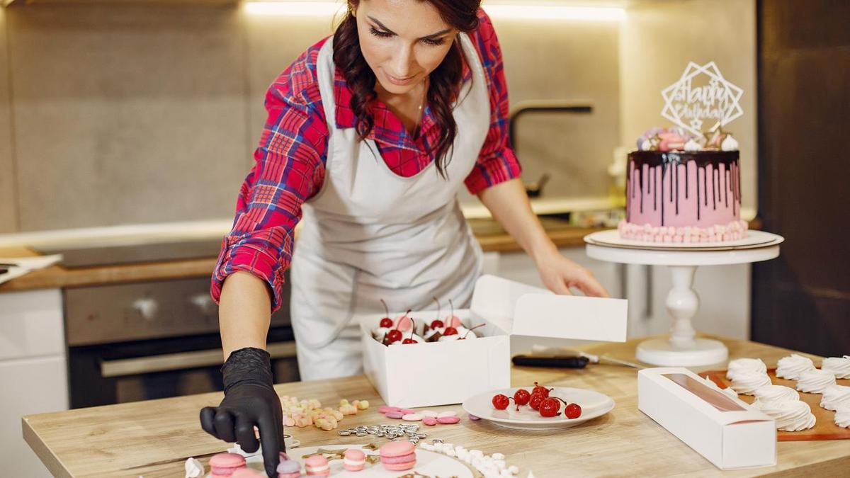 Процесс декорирования торта макарунами, ягодами и топпером