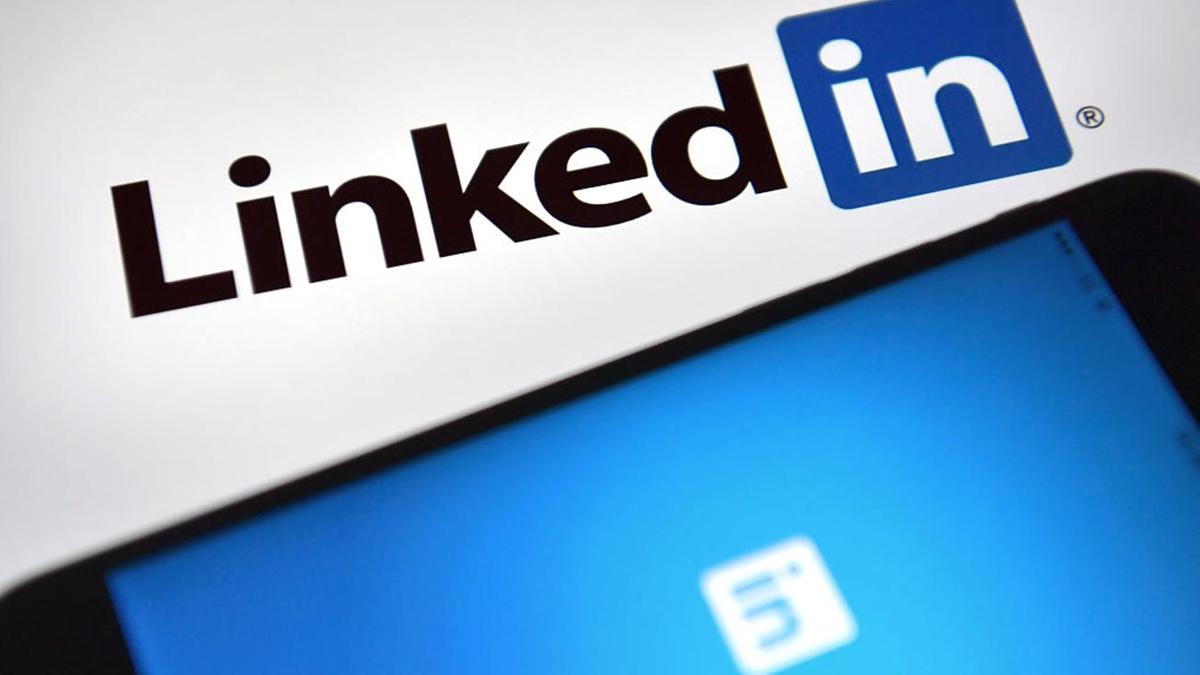 Смартфон с логотипом LinkedIn на экране лежит на столе