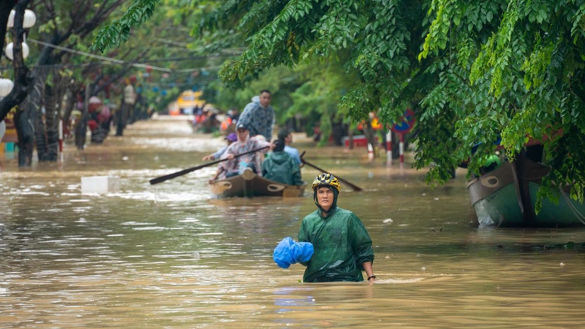 Жители Вьетнама передвигаются на лодках после наводнения.