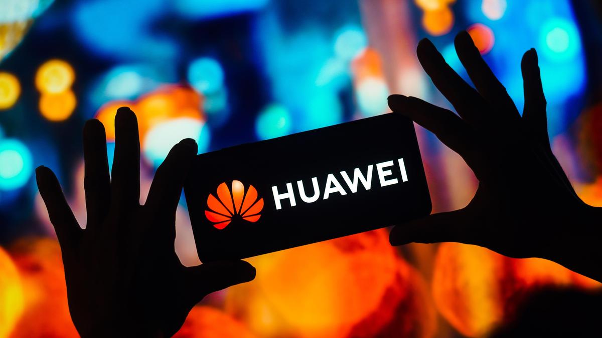 Человек держит смартфон с логотипом Huawei на экране