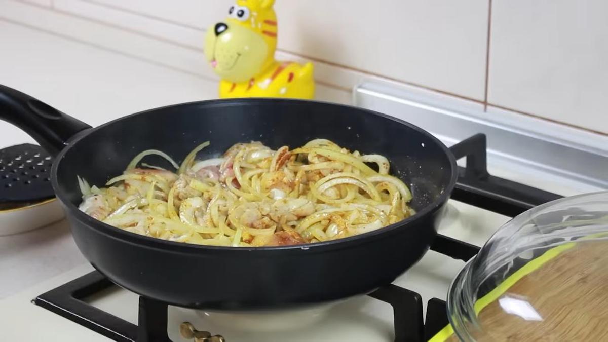 Мясо с луком и специями в сковороде на плите
