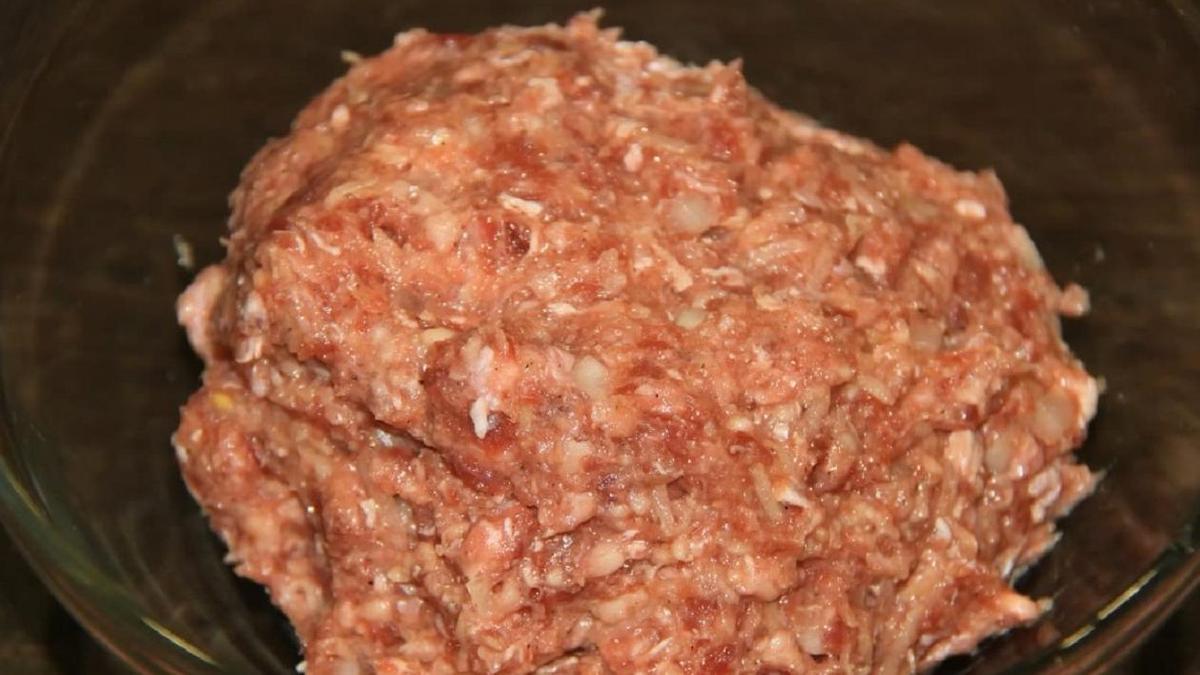 Фарш, смешанный с рубленым луком, тертым картофелем, перцем и сырым яйцом