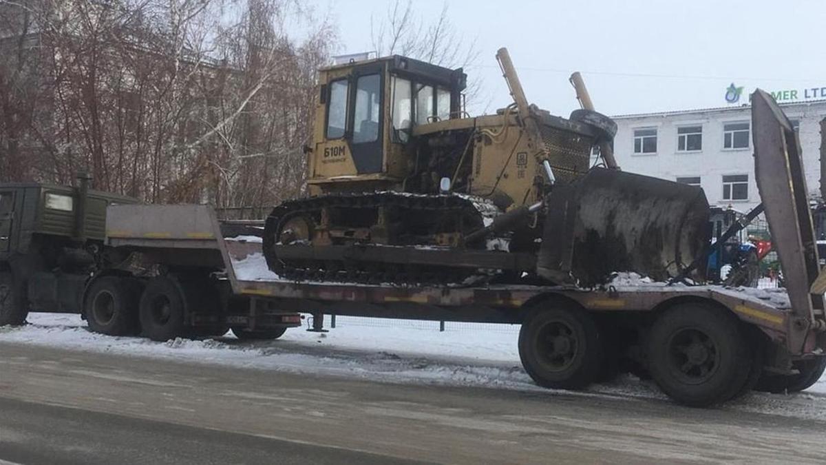 Экскаватор стоит на прицепе грузовика в Петропавловске