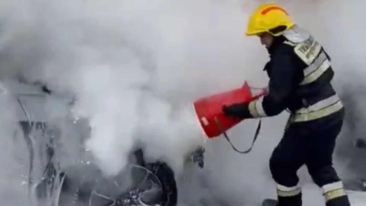 Пожарный тушит автомобиль