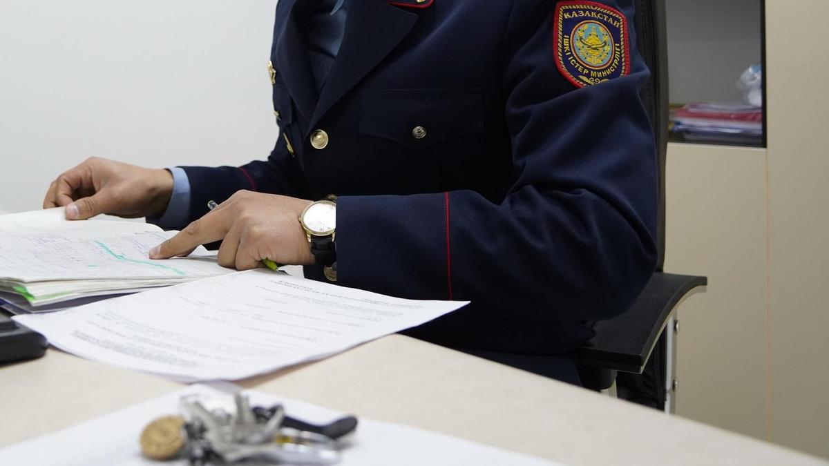 Полицейский в форме сидит за столом Полицейский в форме сидит за столом
