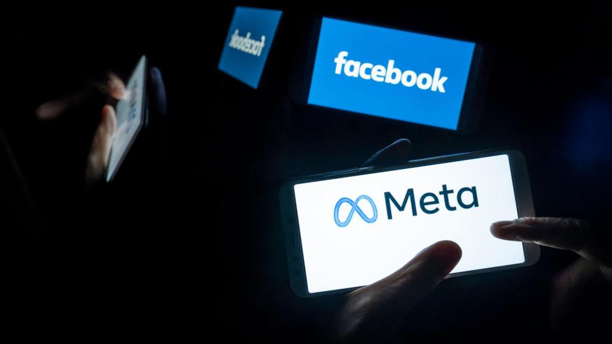 Люди разглядывают логотипы Facebook и Meta