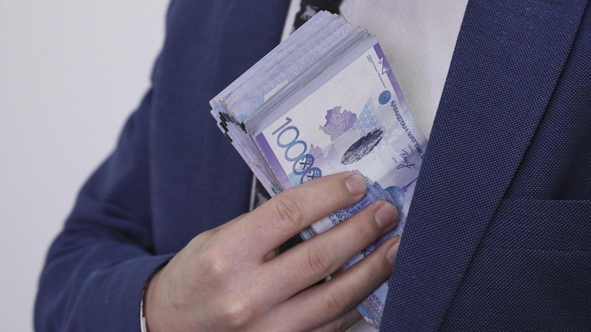 Мужчина кладет крупную сумму денег в карман пиджака Мужчина кладет крупную сумму денег в карман пиджака