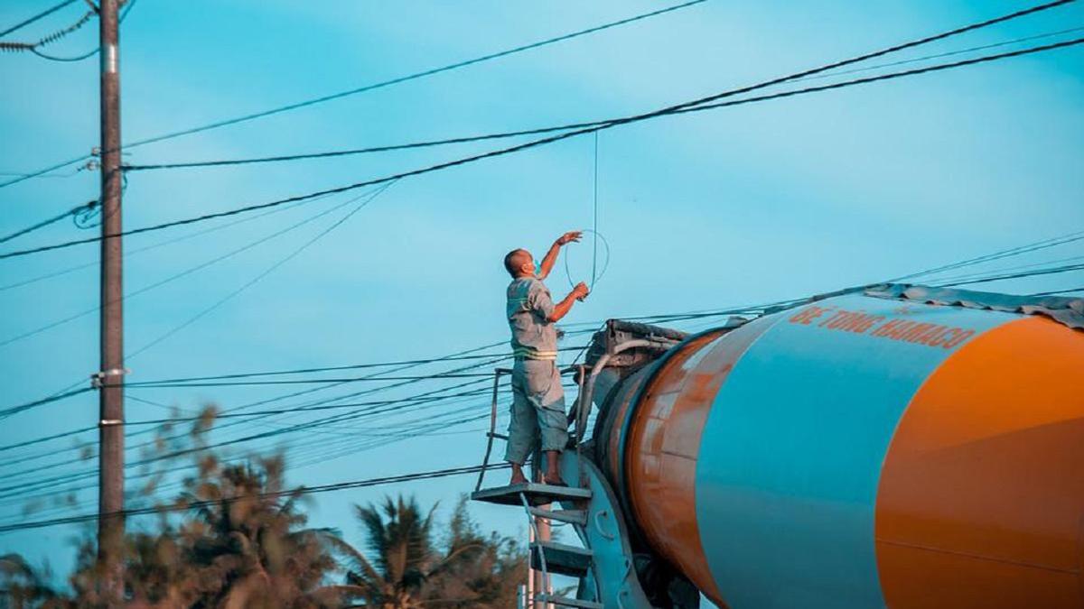 Мужчина стоит возле машины и электропроводов