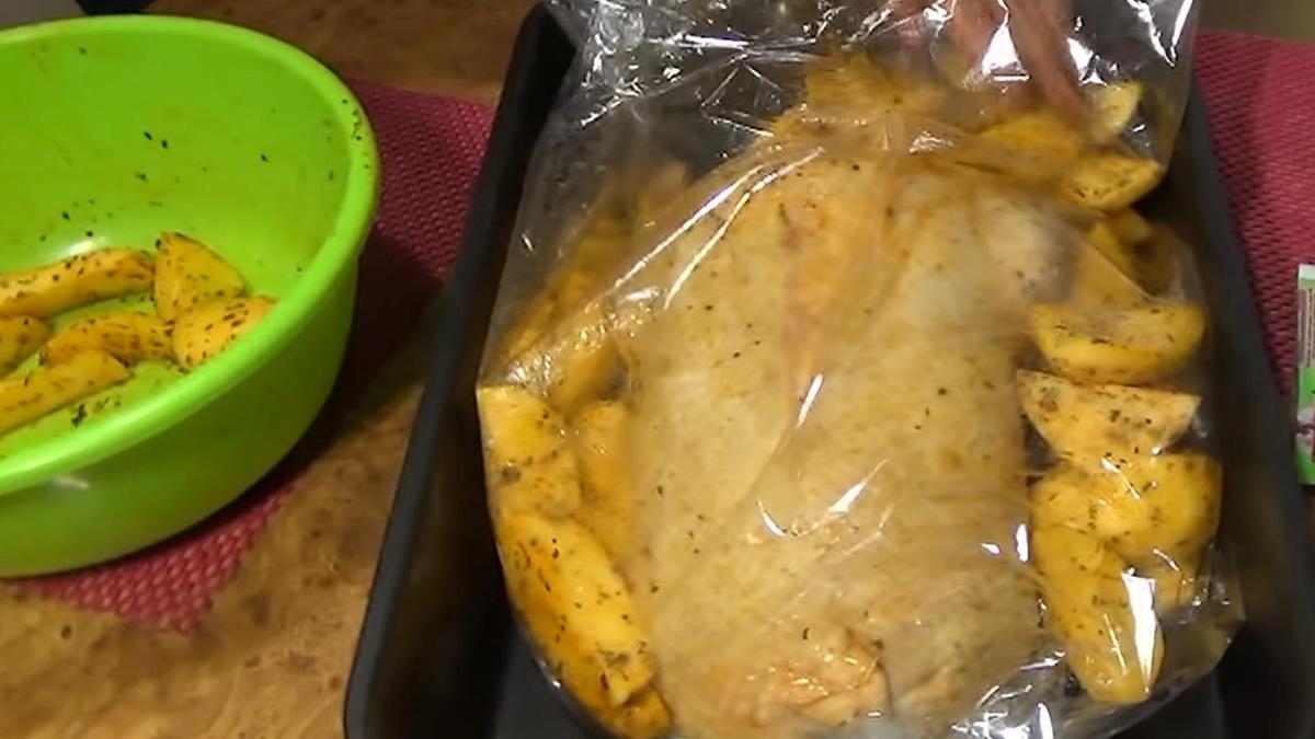 Рукав для запекания, в котором находится гусь, наполняют картофелем