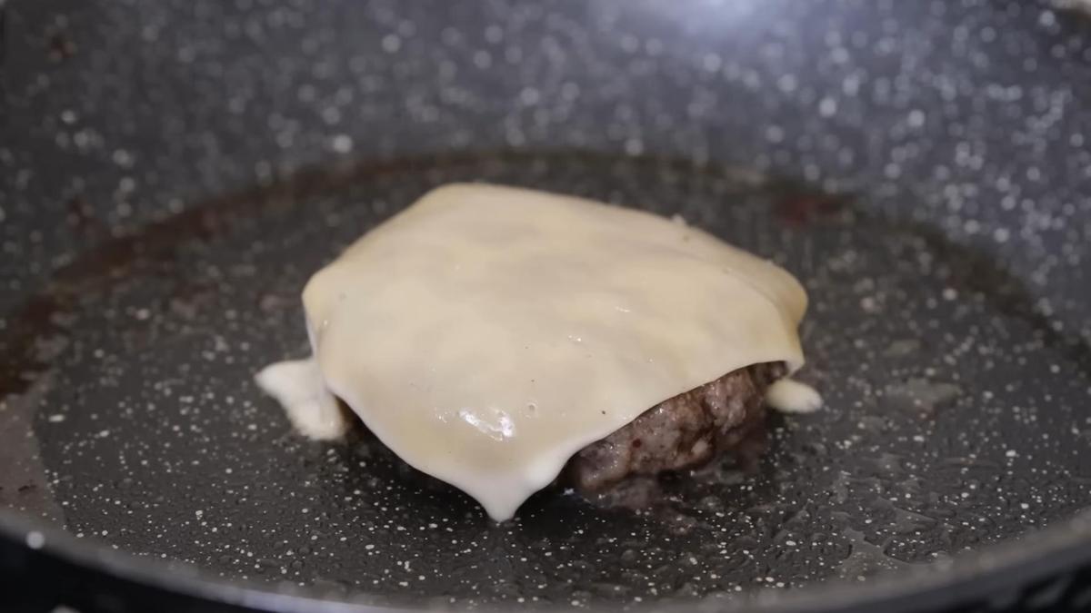 На сковороде котлета с кусочком сыра