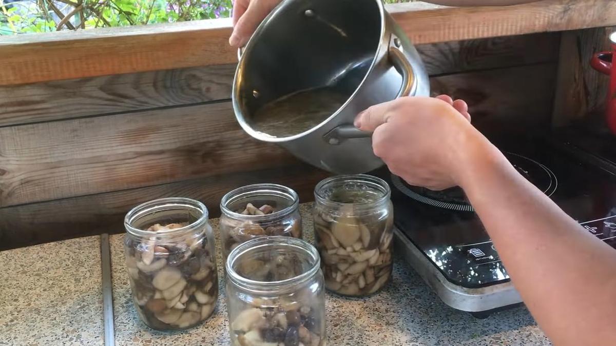 Банки с грибами заполняются маринадом