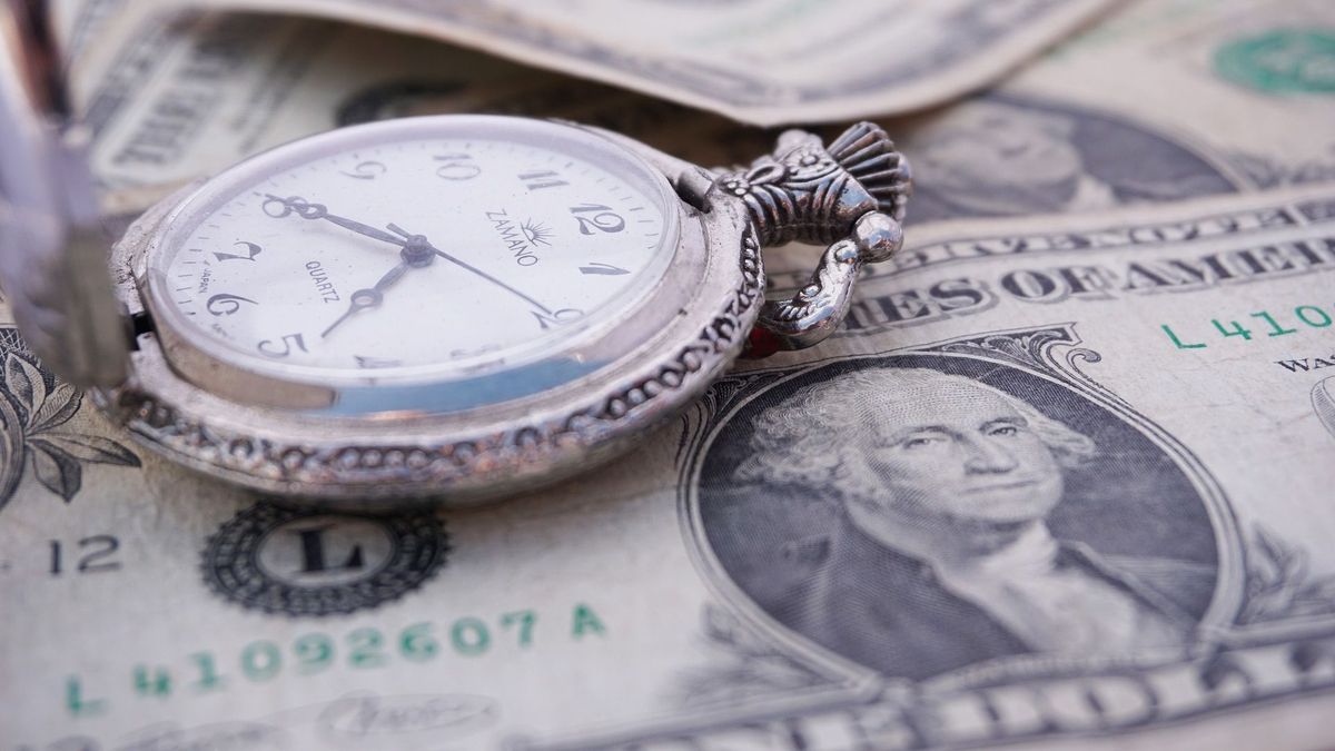 Часы лежат на купюрах долларов