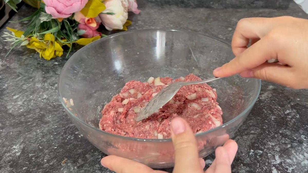 В стеклянной миске смешивают мясной фарш с луком