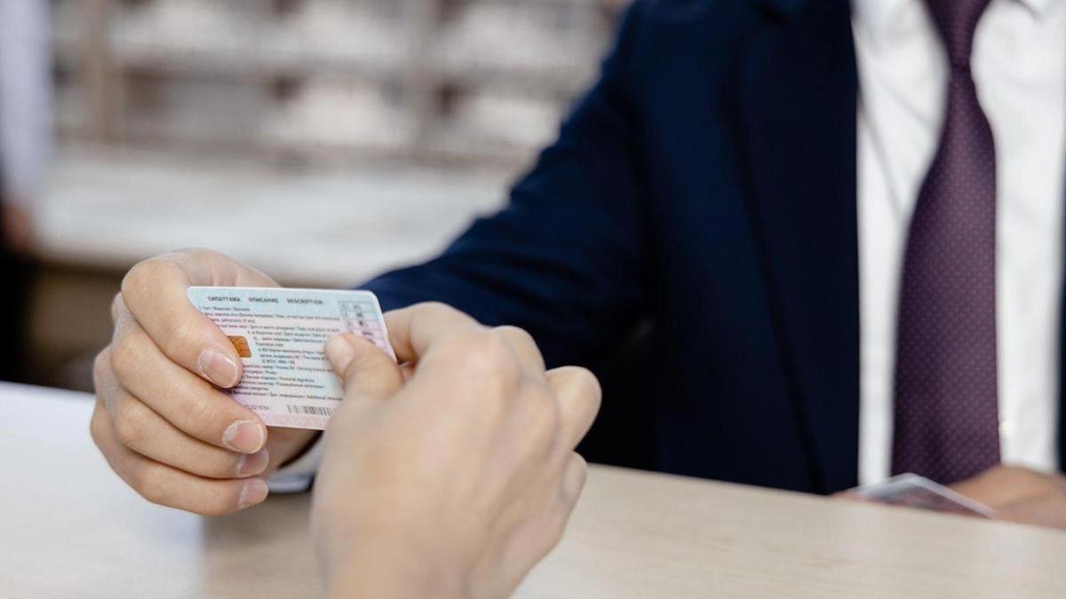 Жүргізуші куәлігі алып жатқан адам әйел Жүргізуші куәлігі алып жатқан адам әйел