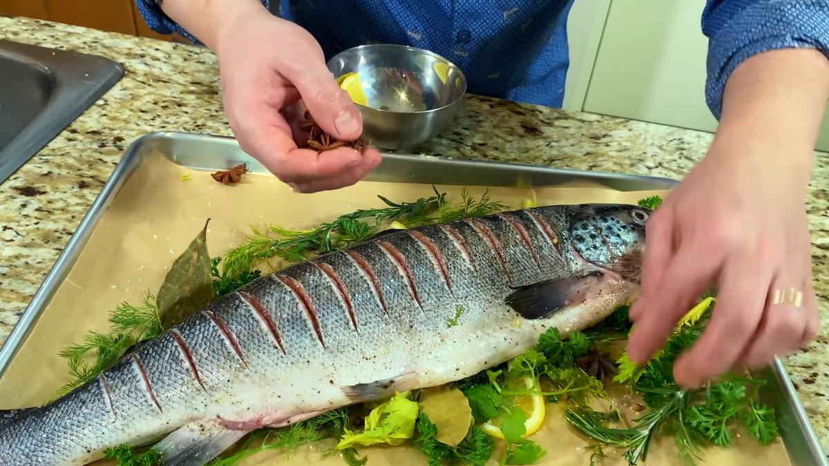 Форель на подушке из свежей зелени на противне