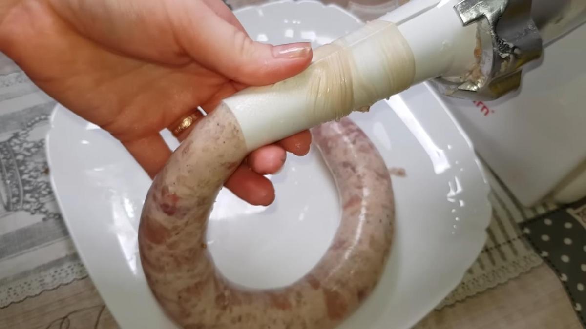 Свиную кишку набивают фаршем через мясорубку