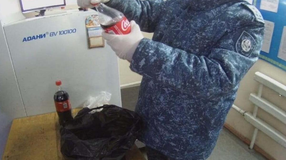 Бутылка Coca-Cola в руках у сотрудника ДУИС