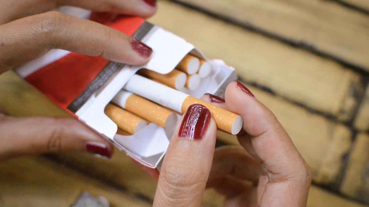 Женщина достает сигареты